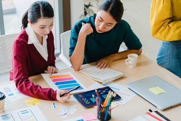 group asia young creative people japanese female boss supervisor teaching intern new employee hispanic girl helping with difficult assignment modern office coworker teamwork concept(1)